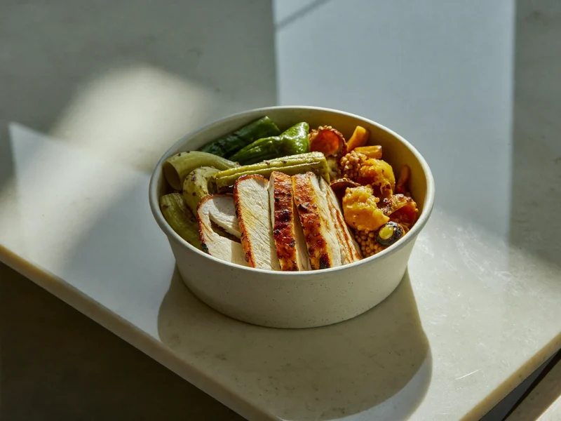 Bowl mit Röstgemüse und gegrilltem Hähnchen in kompostierbarer Schale